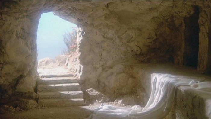 En grotte med stenvegger og en åben ingang til en udendørs område.