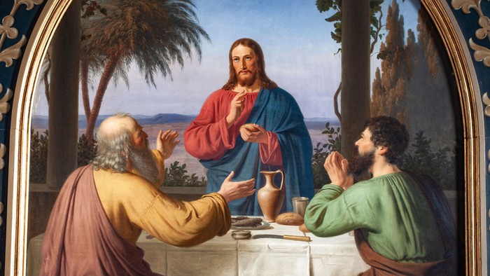 Billedet viser Jesus og to andre mænd ved et bord med mad.