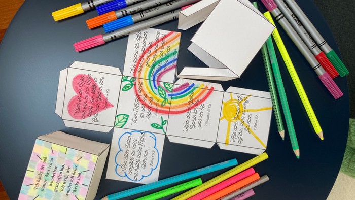 Bunte Stifte und selbstgebastelte Karten auf einem Tisch