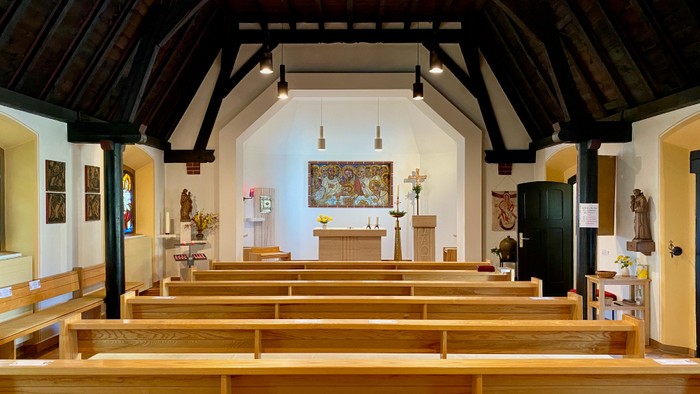 Kirchliche Innenansicht mit Holzgestühl und Altar