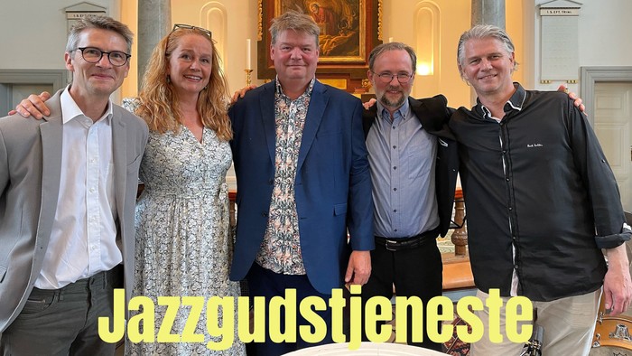 En gruppe af fem personer poser til et billede i en indendørs lokalitet med kolonner og hængende lygter.
