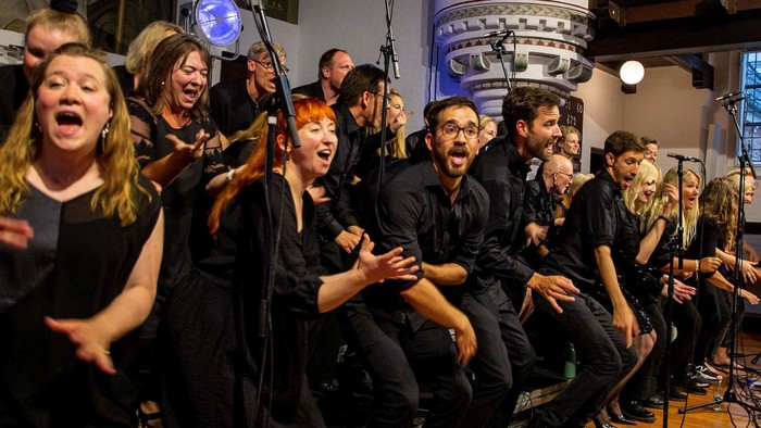 En gruppe af musikere optræder på en scene med mikrofoner og instrumenter