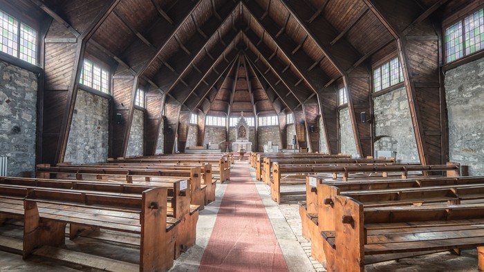 Alte Holzkirche mit hölzernen Bänken und hoher Decke