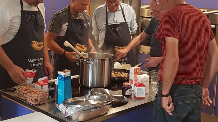 Fire mænd koker sammen i en professionel køkken.
