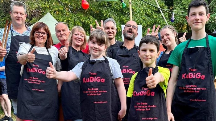 Gruppe von Menschen, die Schürzen tragen und Daumen hoch zeigen.