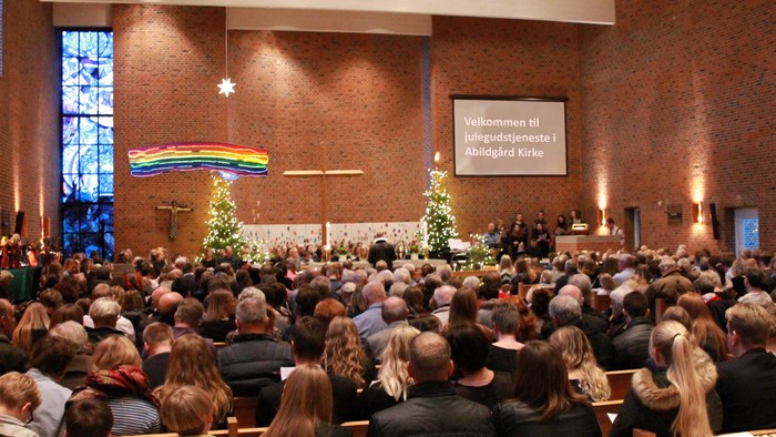 En stor kirkefuld med juledekorationen og en folkemasse.