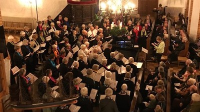 En stor kor, der synger i en kirke.