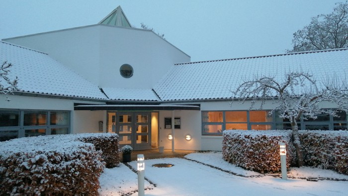 En snedækket moderne villa med skråt tak og lysende vinduer