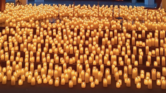 Hunderte von brennenden Kerzen in Reihen angeordnet, die eine warme und friedvolle Atmosphäre schaffen.