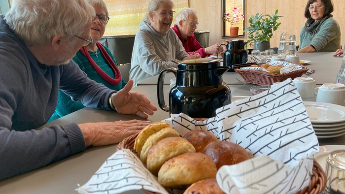 Mødebord med kaffe, bagværk og mødedeltagere