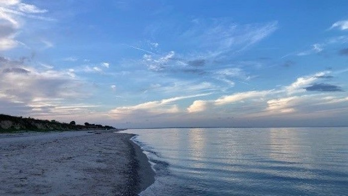 Sandstrand am Meer mit Wolkenspiel im Himmel