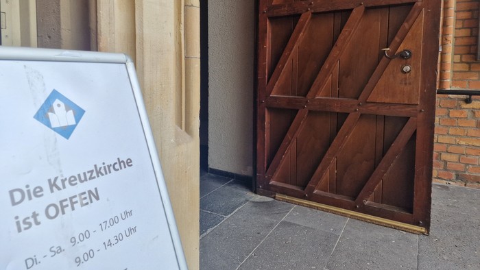 Die Kreuzkirche ist geöffnet, Holztür mit zwei Flügeln