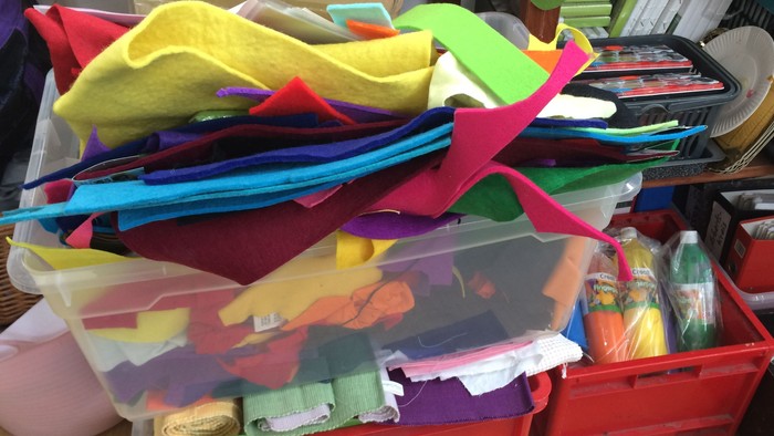 Bunte Stoffe und Materialien in Kisten und Boxen.