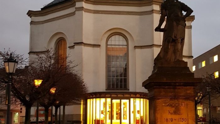 Statue vor einem beleuchteten Gebäude bei Nacht