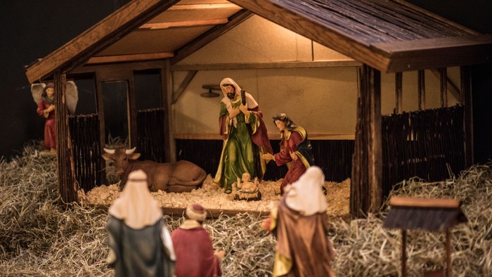 En julekrybbe med figurer og dyr i en stald.