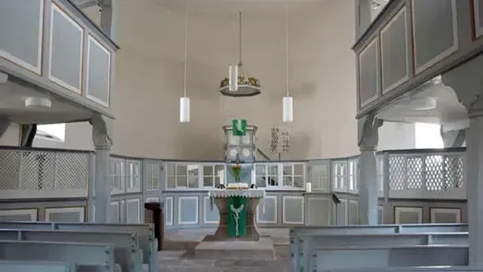 Kircheninneres mit Kirchenbänken, Altar und Kronleuchter