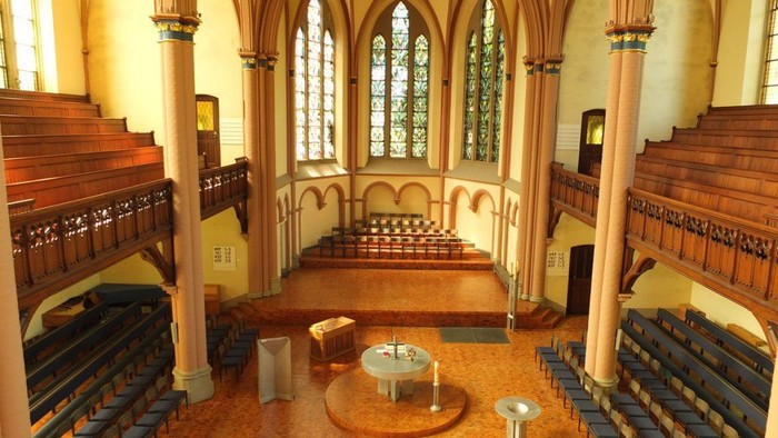 Gothische Kirche mit hohen Decken, Buntglasfenstern und Holzgestühl