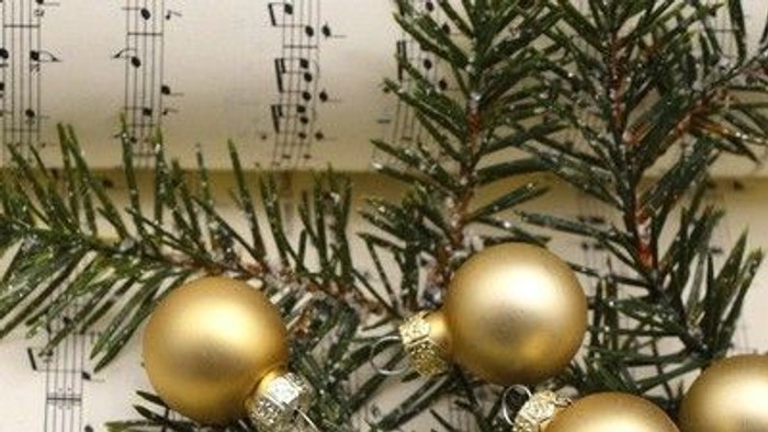 Goldene Christbaumkugeln auf grünen Tannenzweigen