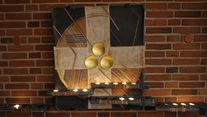 Abstrakt kunstværk med gyldne kugler på murstensvæg