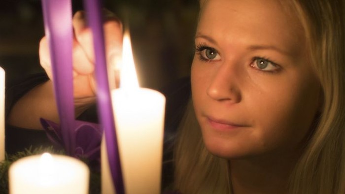 En ung pige ser træt ud mellem lysende lysstaker og violette bælter.