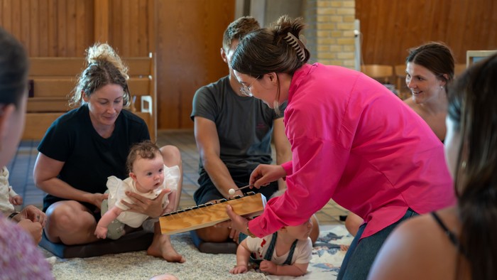 En gruppe af kvinder og børn spiller på gulv.