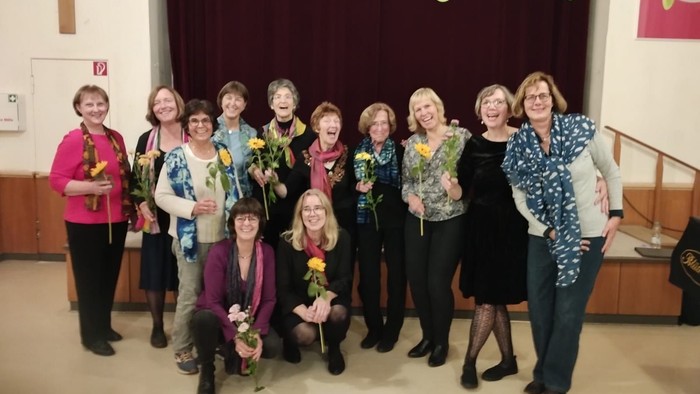 Ein Gruppe von Frauen feiert gemeinsam in einem Raum mit Dekorationen.