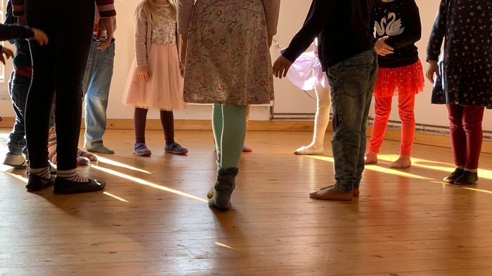 Kinder tanzen in einer Reihe auf einem Holzboden