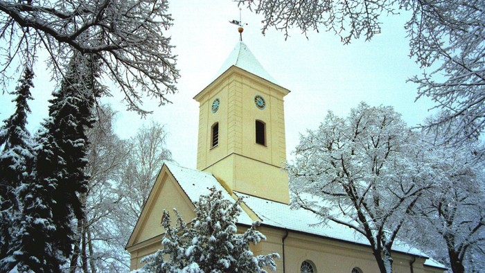 Weiße Kirche mit Uhrturm im Winter