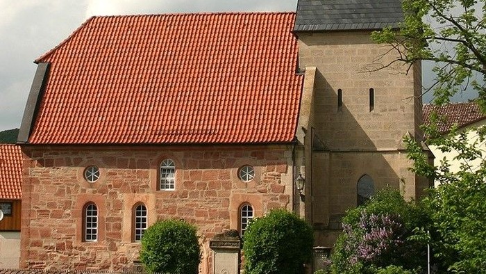 Kirche mit hohem Turm und rotem Dach.