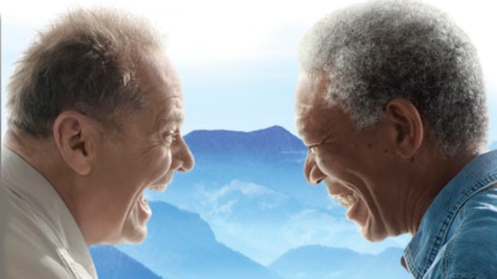 To the book cover shows two elderly men shaking hands against a scenic mountain backdrop.