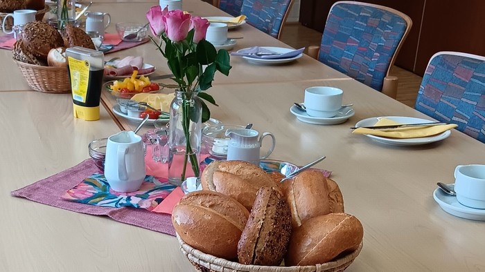 Frühstückstisch mit Brot, Wurst, Gemüse und Tee