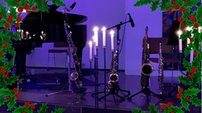 Musikinstrumenter udstillet på scenen med lys og julepynt.