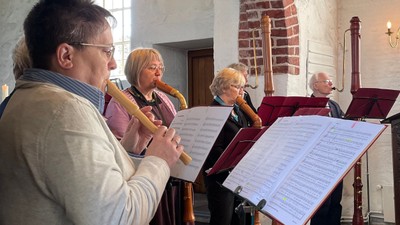 Eine Gruppe von Musikern spielt in einem Kirchenraum.