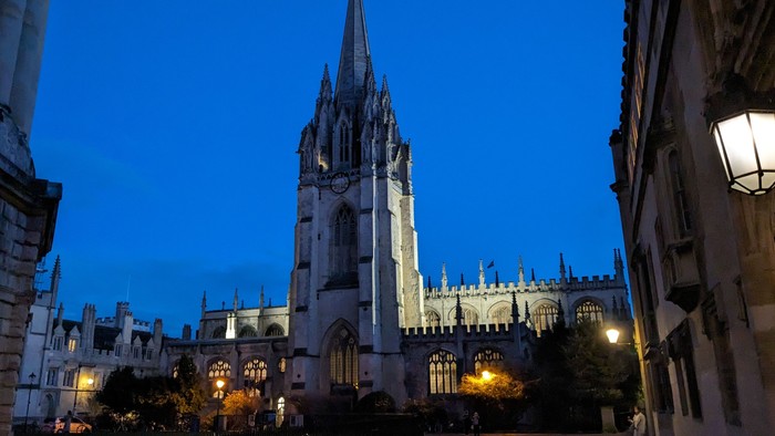 Gothische Kathedrale bei Nacht mit umgebenden Gebäuden und Straßenlaternen