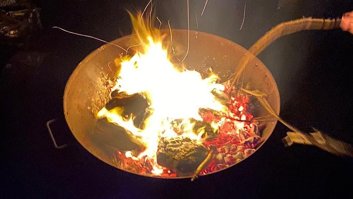 Menschen um ein Lagerfeuer bei Nacht