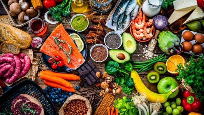 Billede af en lang række friske og udbredte madvarer, inklusive frugter, grønne og proteinrige fødevarer.