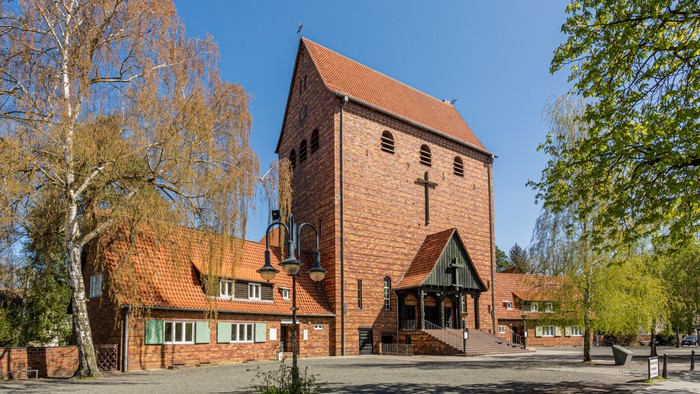 Kirchengelände mit Hauptgebäude und Bäumen unter klarem Himmel