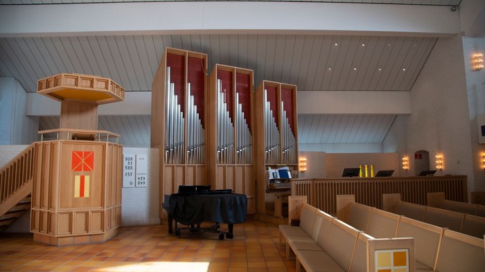 Indre del af kirke med orgel og bænke.