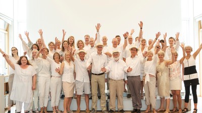 En gruppe glade og eldre personer poserende sammen.