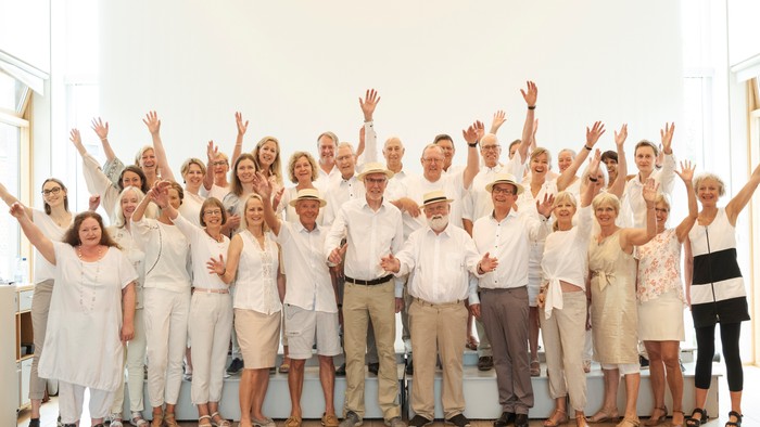 En gruppe glade og eldre personer poserende sammen.