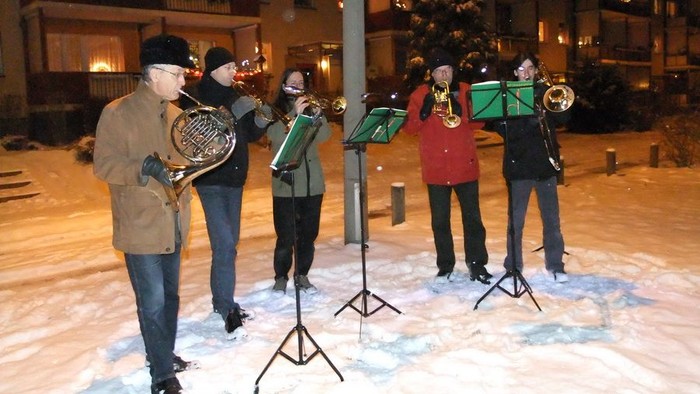 Eine Gruppe von Musikern spielt im Schnee verschiedene Blasinstrumente