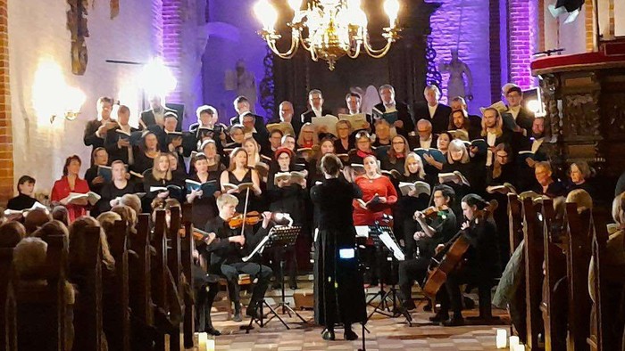 En kirke med en stor kor og orkester, lysekerler foran.