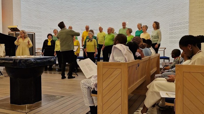 En gruppe af mennesker i en kirke, nogle står, nogle sidder