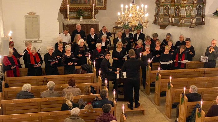 En kirke med kor, der synger, mens forsamlingen tilskuer.