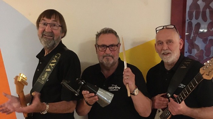 Tre mænd står sammen med guitarer og priser