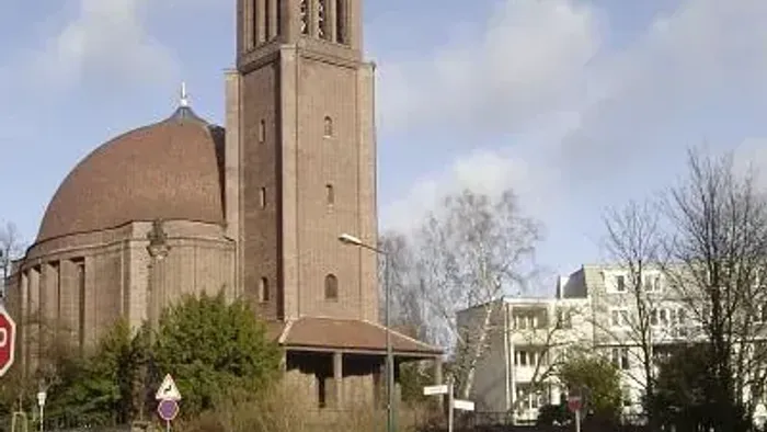 Kirche St. Georg mit rundem Kuppeldach und kegelförmiger Turmspitze.