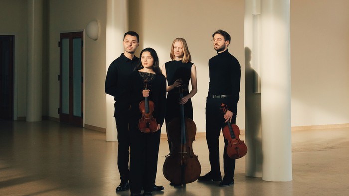 Fire musikerer med violiner i moderne hal