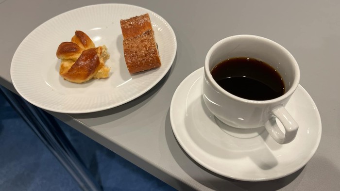 En kaffekop og en ret med småkager på en hvid plate.