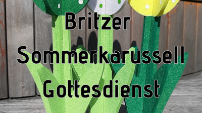 Drei bunte Blumen aus Filz mit weißen Punkten und grünen Stielen auf Holzoberfläche