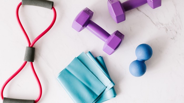 Es sind Theraband, Hanteln und Expander zu sehen